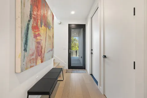 a view of a hallway with wooden floor and staircase
