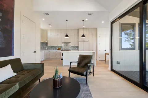 a living room with kitchen island furniture and a chandelier