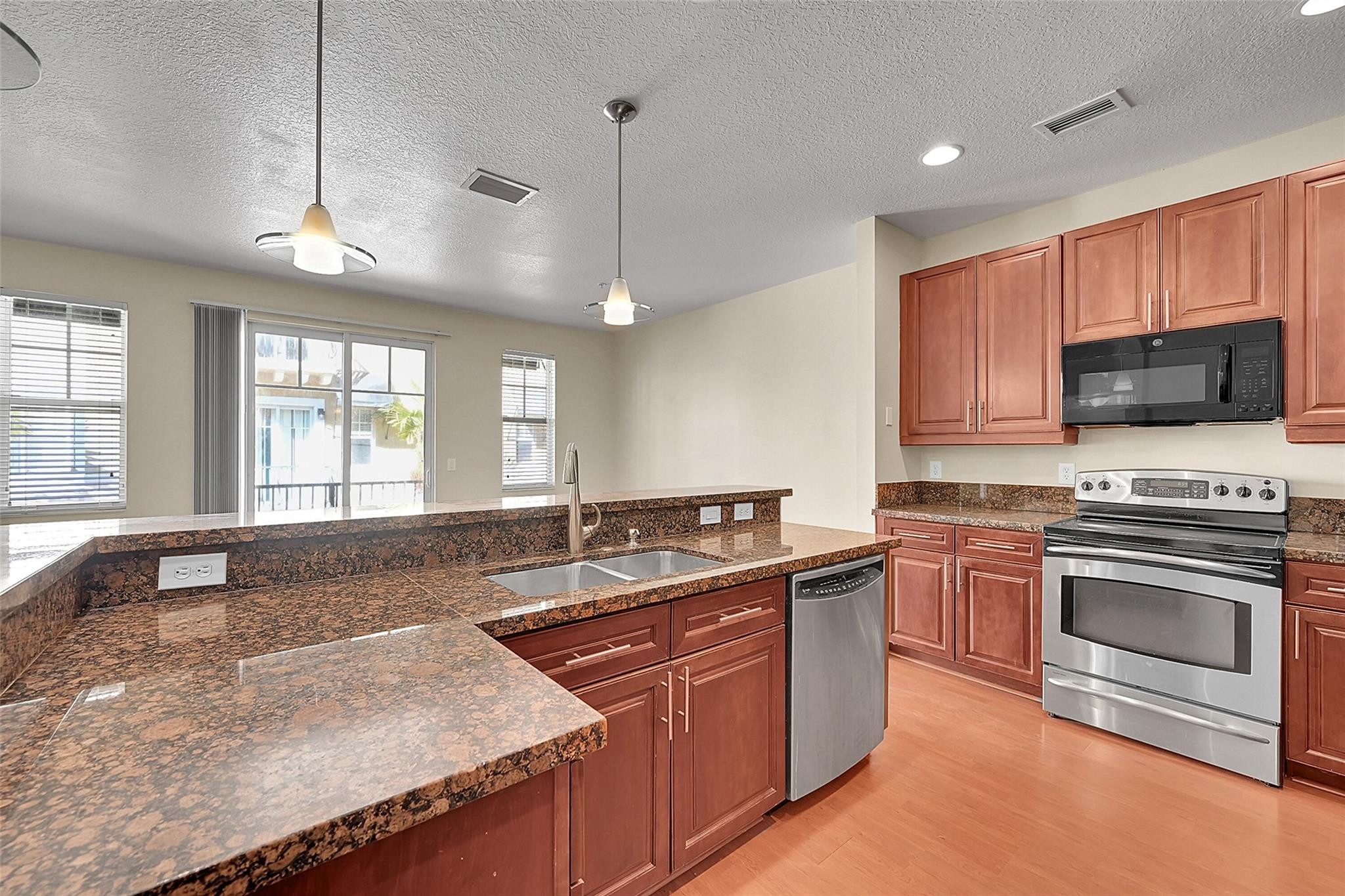 3605 Northwest 5th Terrace Boca Raton, FL 33431 - Photo 14 of 48 a kitchen with stainless steel appliances granite countertop a sink stove and oven
