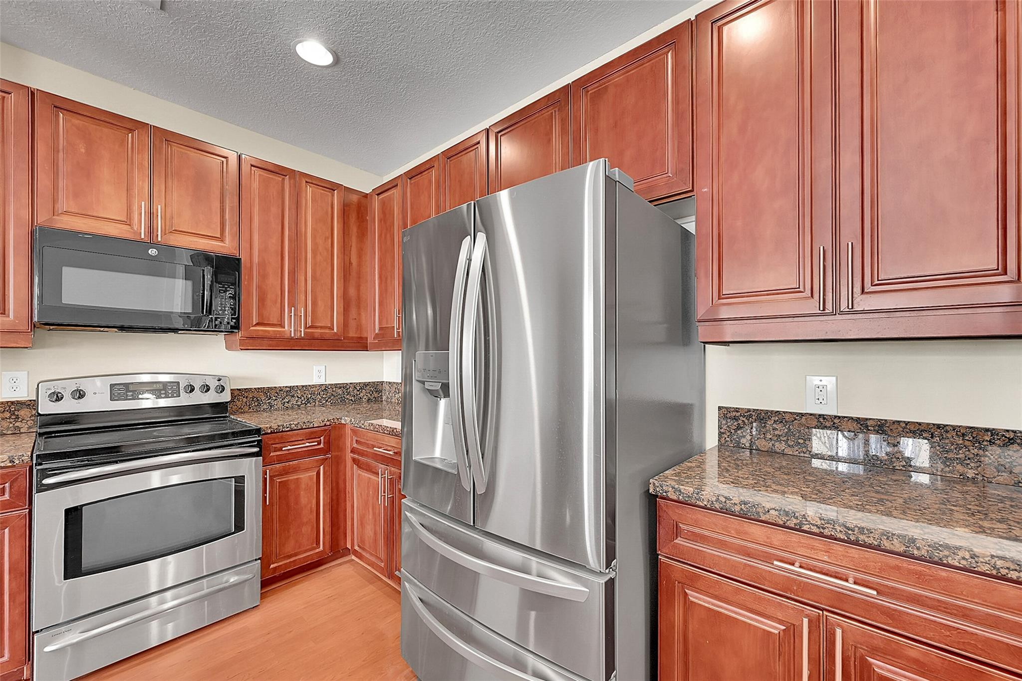 3605 Northwest 5th Terrace Boca Raton, FL 33431 - Photo 15 of 48 a kitchen with granite countertop a refrigerator stove and microwave
