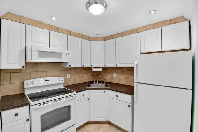 a kitchen with a white cabinets and white appliances
