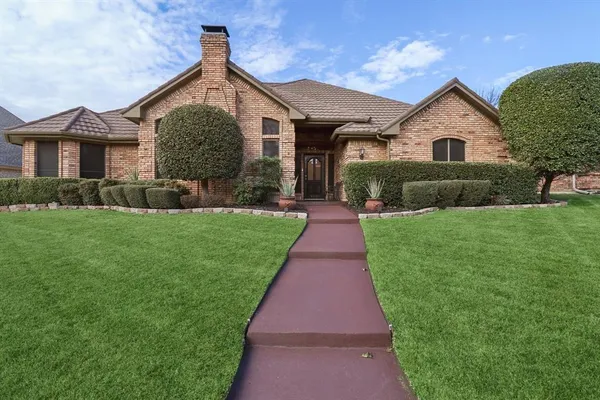 a front view of a house with a yard and potted plants