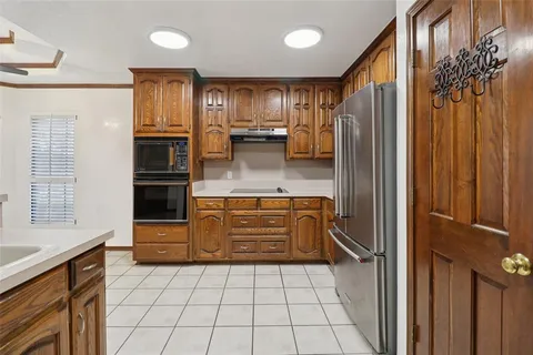 a kitchen with kitchen island granite countertop a refrigerator and a sink