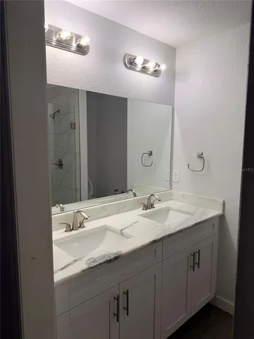 a bathroom with a double vanity sink and a mirror