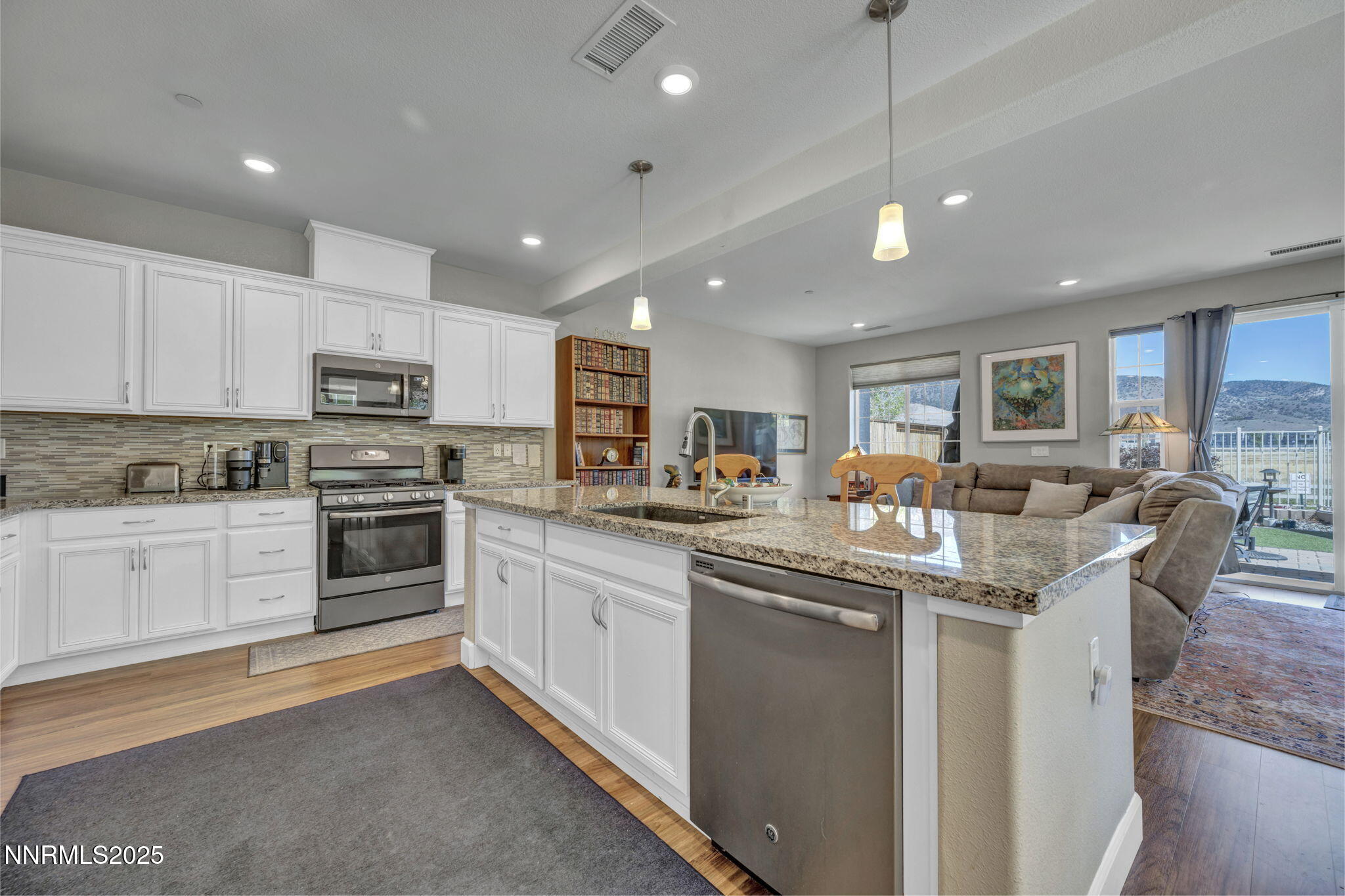 1940 Dark Horse Road, Unit C Reno, NV 89521 - Photo 61 of 69 a kitchen with stainless steel appliances kitchen island granite countertop a stove top oven a sink a dining table and chairs