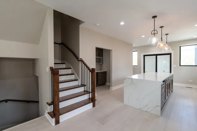 a kitchen with stainless steel appliances kitchen island granite countertop a refrigerator and a stove top oven