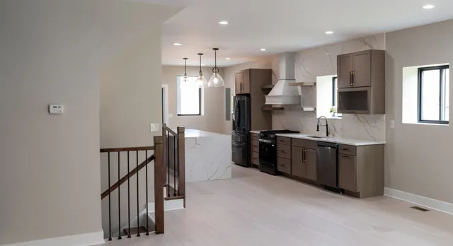 a kitchen with stainless steel appliances granite countertop a sink a stove and a refrigerator