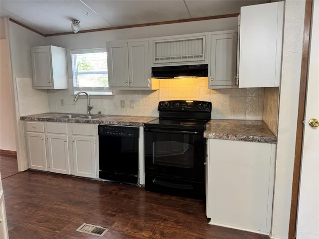 a kitchen with a sink and a stove top oven