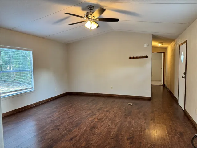 an empty room with a window and a ceiling fan