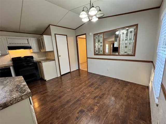 a view of a livingroom with wooden floor and furniture