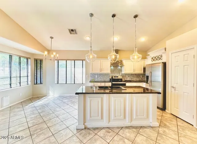 a kitchen with stainless steel appliances granite countertop a stove a sink and a refrigerator