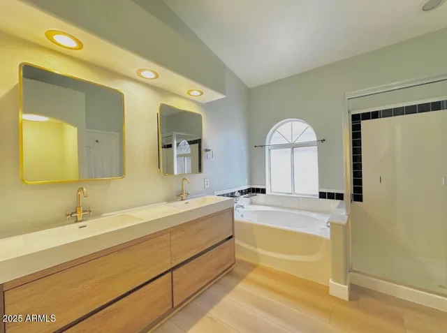 a spacious bathroom with a tub sink and mirror