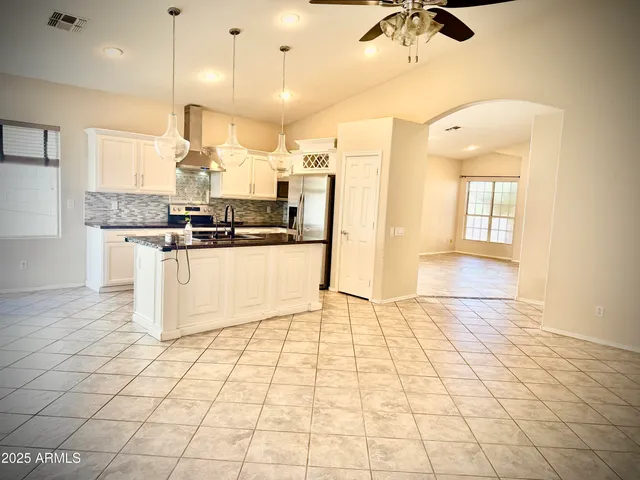 a kitchen with stainless steel appliances granite countertop a stove a sink and a refrigerator