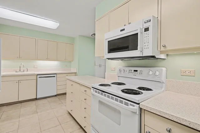 a kitchen with white cabinets and refrigerator