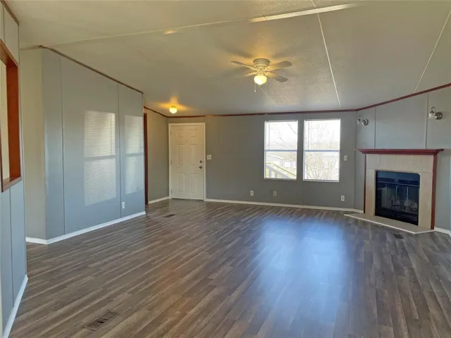 an empty room with wooden floor and fireplace