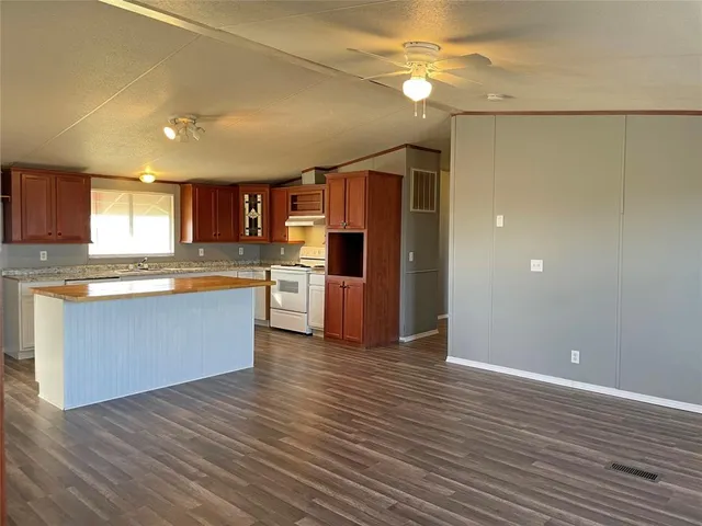 a kitchen with stainless steel appliances granite countertop a refrigerator and a stove top oven