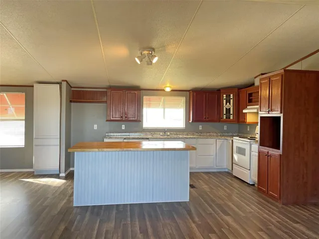 a kitchen with stainless steel appliances granite countertop a stove a sink dishwasher a refrigerator and wooden floor
