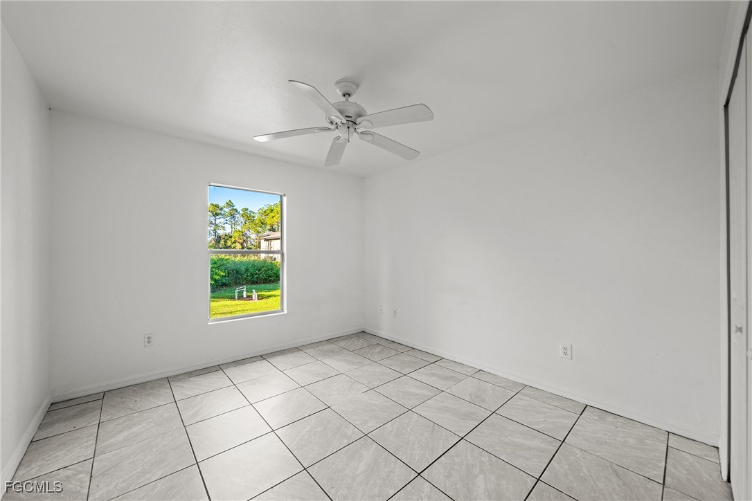 4735 30th Street Southwest Lehigh Acres, FL 33973 - Photo 13 of 43 an empty room with windows and ceiling fan