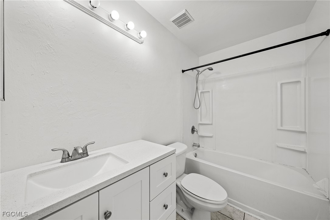 4735 30th Street Southwest Lehigh Acres, FL 33973 - Photo 14 of 43 a bathroom with a sink toilet vanity and shower