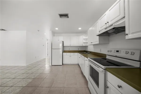 a large kitchen with stainless steel appliances granite countertop a sink and cabinets