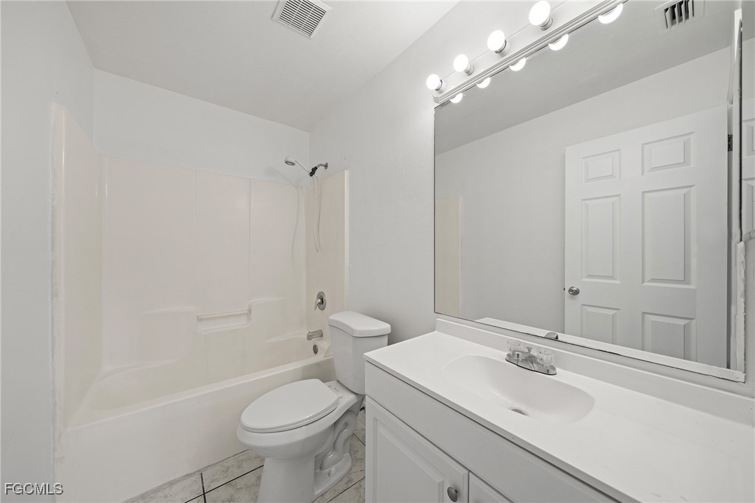 4735 30th Street Southwest Lehigh Acres, FL 33973 - Photo 26 of 43 a bathroom with a sink a toilet and shower