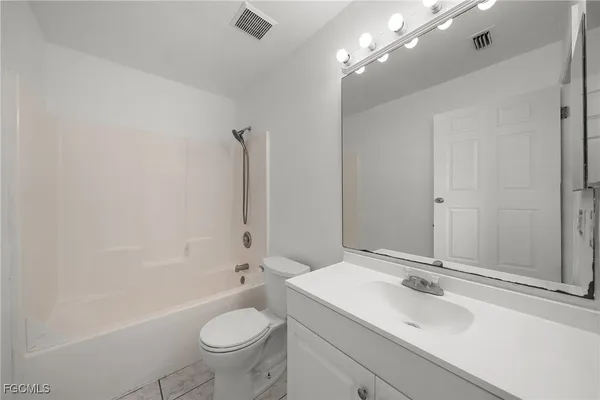 a bathroom with a sink a toilet a mirror and shower