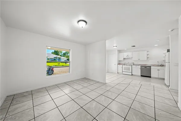 a view of kitchen with stainless steel appliances cabinets and window