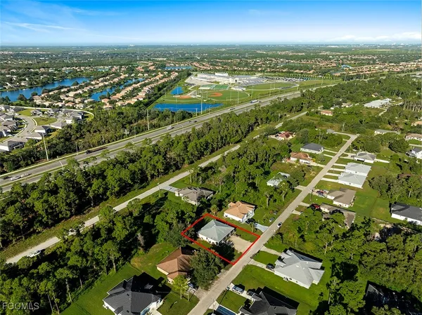 an aerial view of residential houses with outdoor space and trees
