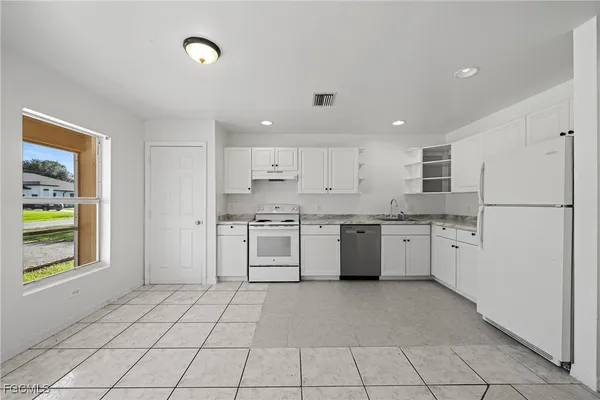 a kitchen with white cabinets and white appliances