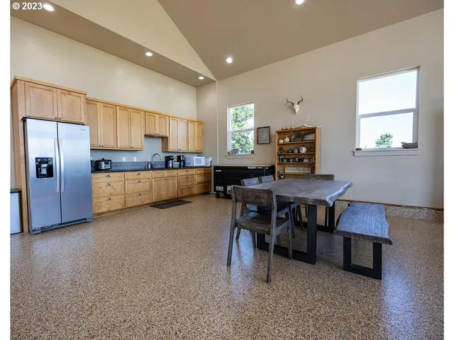 a living room with stainless steel appliances kitchen island granite countertop furniture and a refrigerator