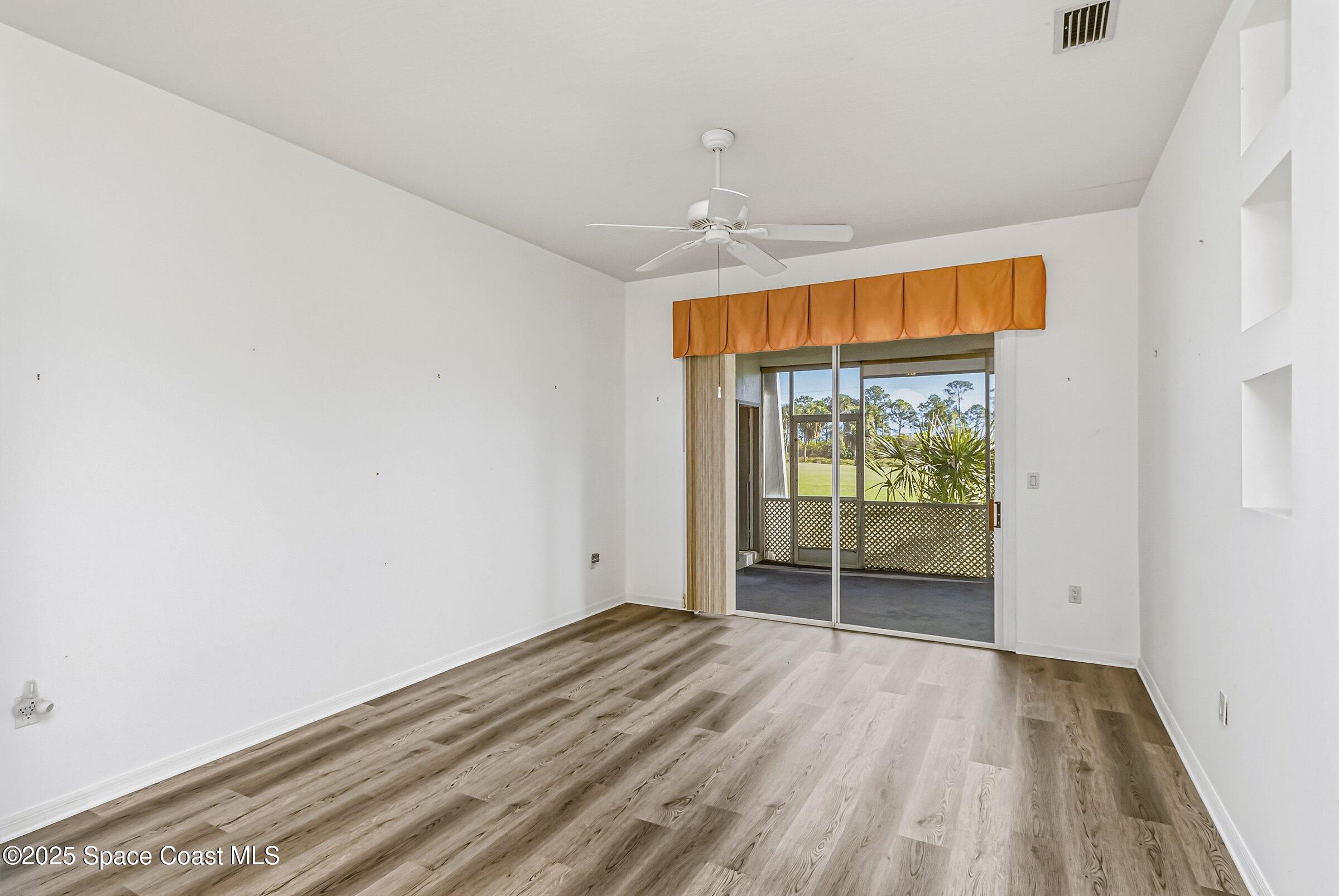 4048 Sand Ridge Drive Merritt Island, FL 32953 - Photo 13 of 70 an empty room with wooden floor and balcony