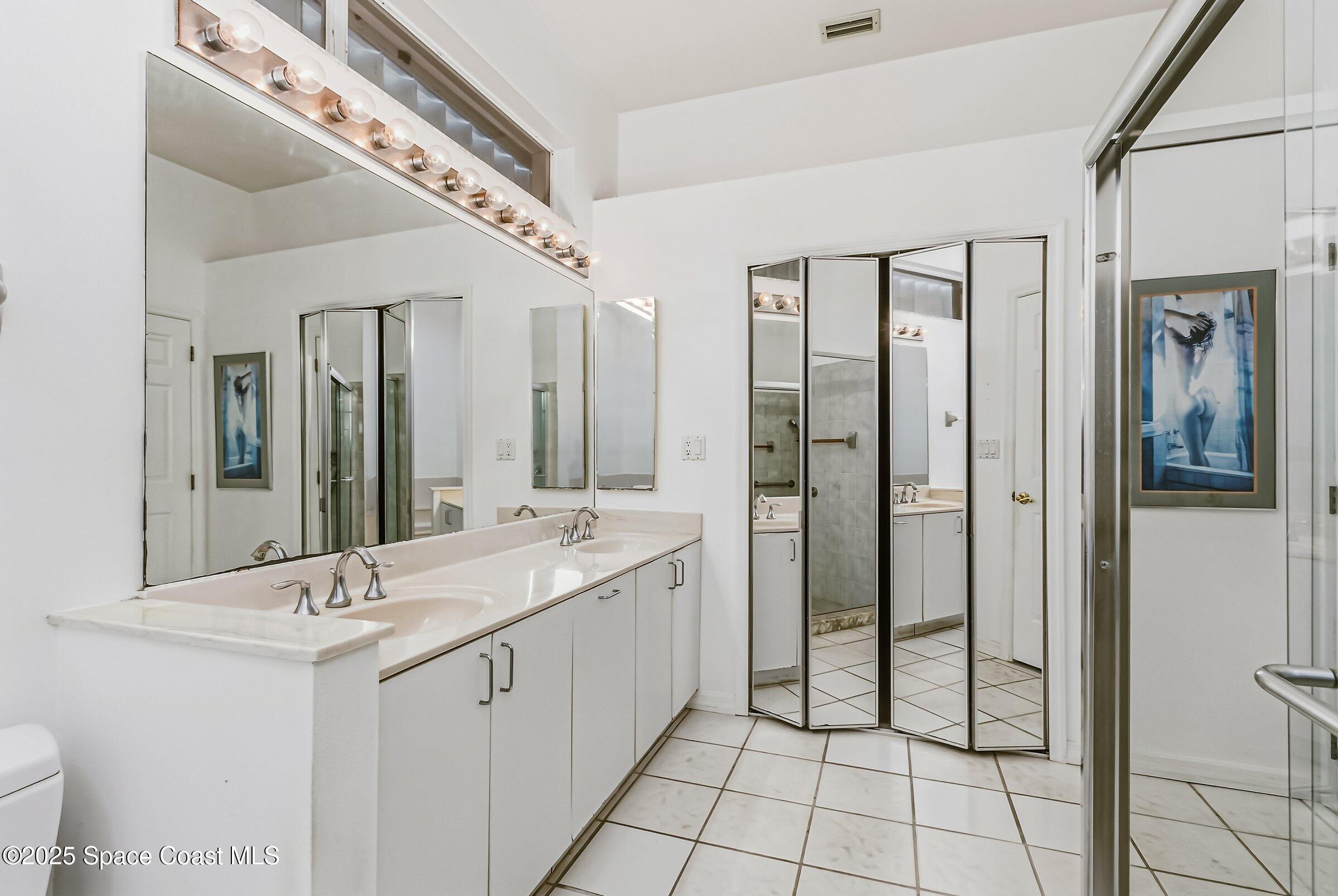 4048 Sand Ridge Drive Merritt Island, FL 32953 - Photo 25 of 70 a spacious bathroom with a double vanity sink a mirror and a shower