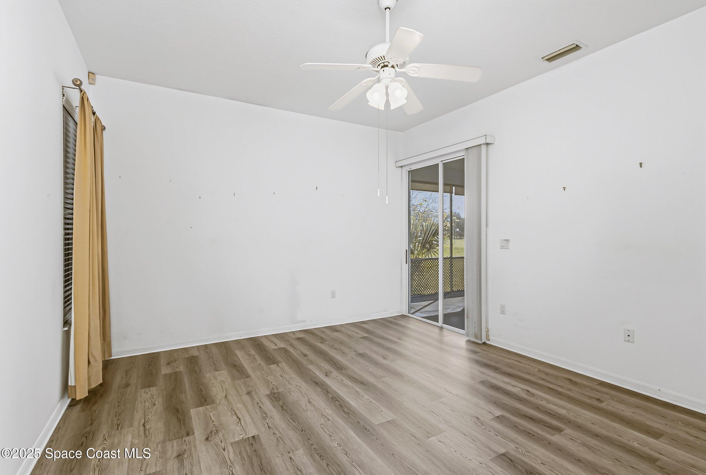 4048 Sand Ridge Drive Merritt Island, FL 32953 - Photo 27 of 70 an empty room with wooden floor fan and windows