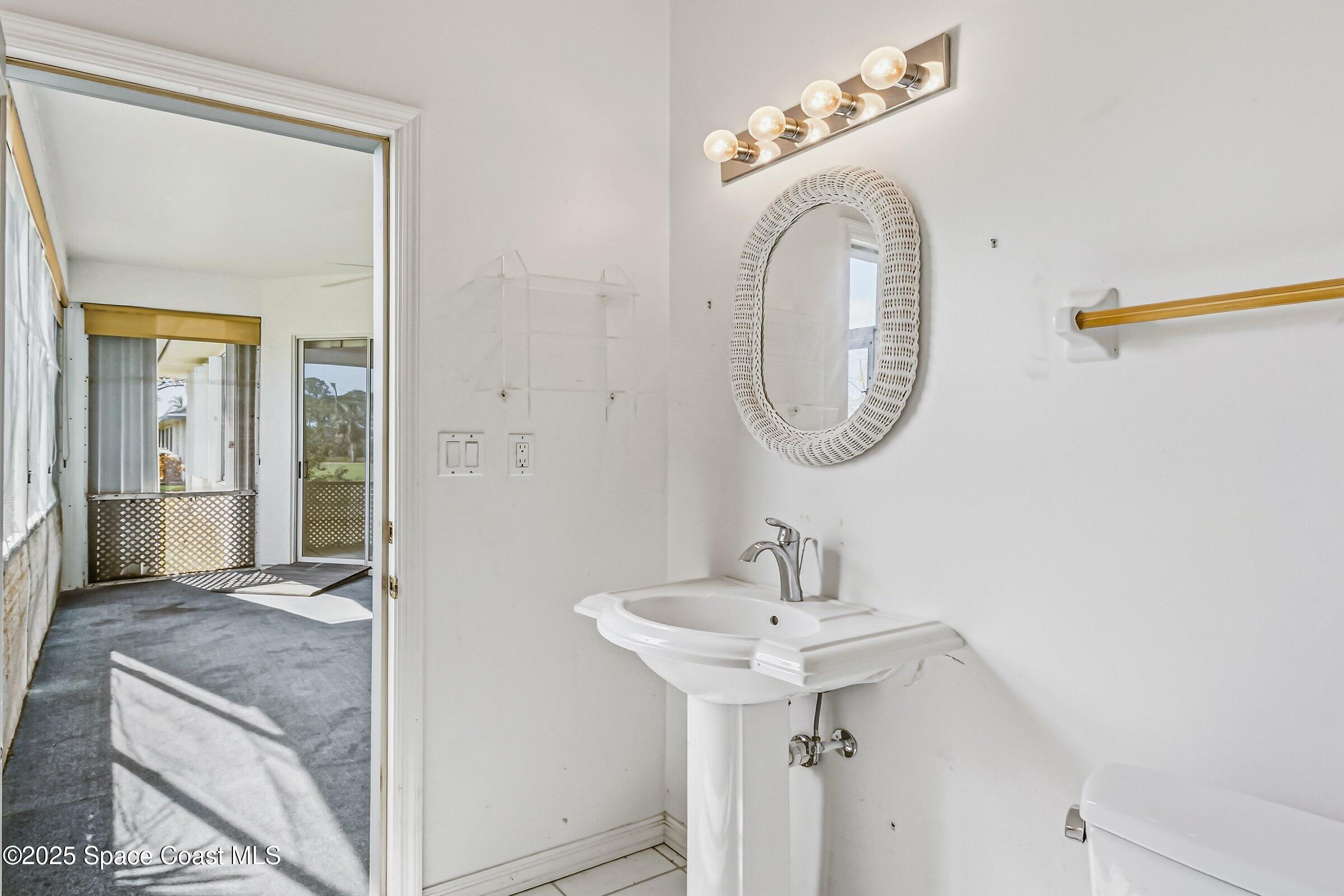 4048 Sand Ridge Drive Merritt Island, FL 32953 - Photo 30 of 70 a bathroom with a sink and a mirror