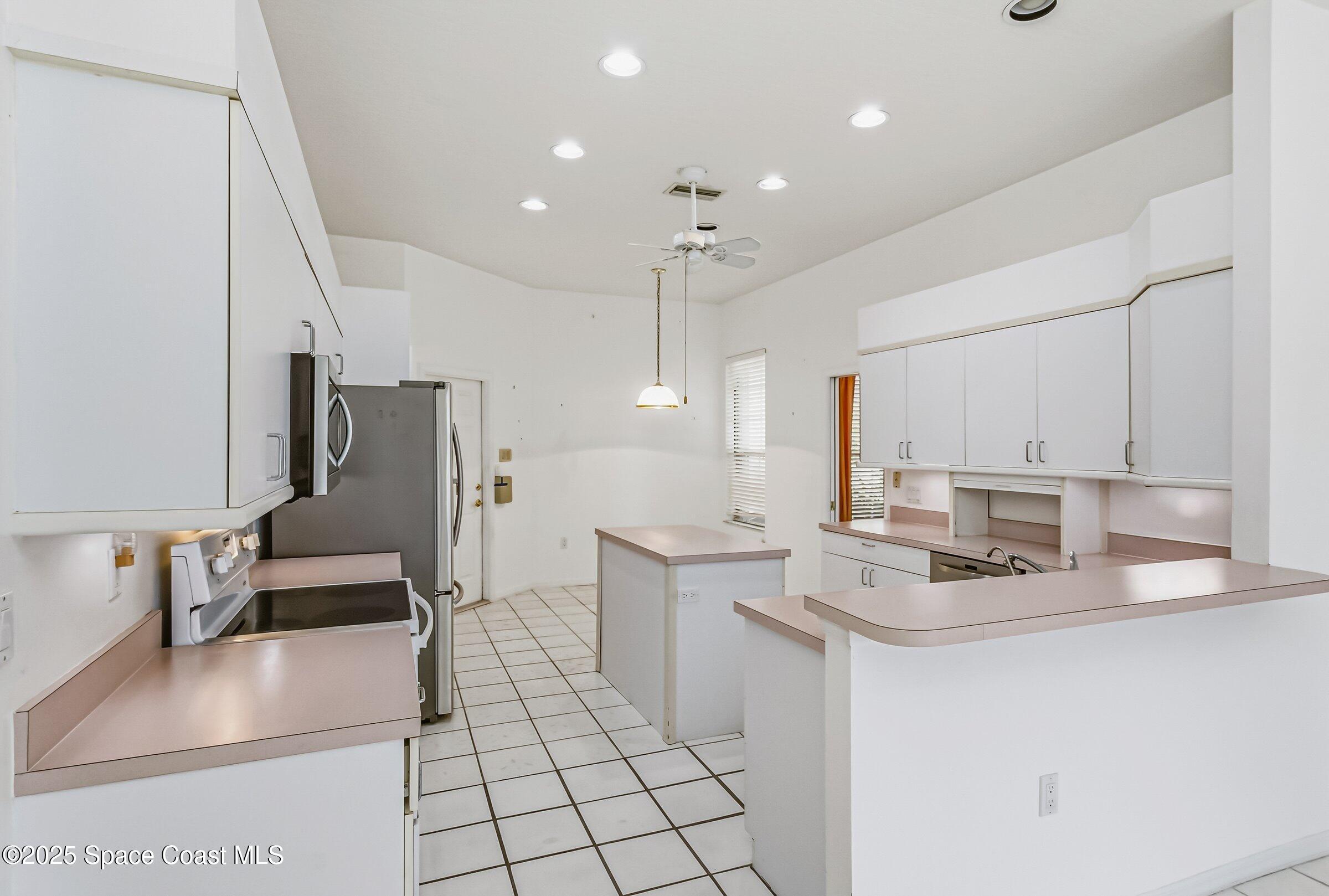 4048 Sand Ridge Drive Merritt Island, FL 32953 - Photo 44 of 70 a kitchen with stainless steel appliances a refrigerator sink and microwave