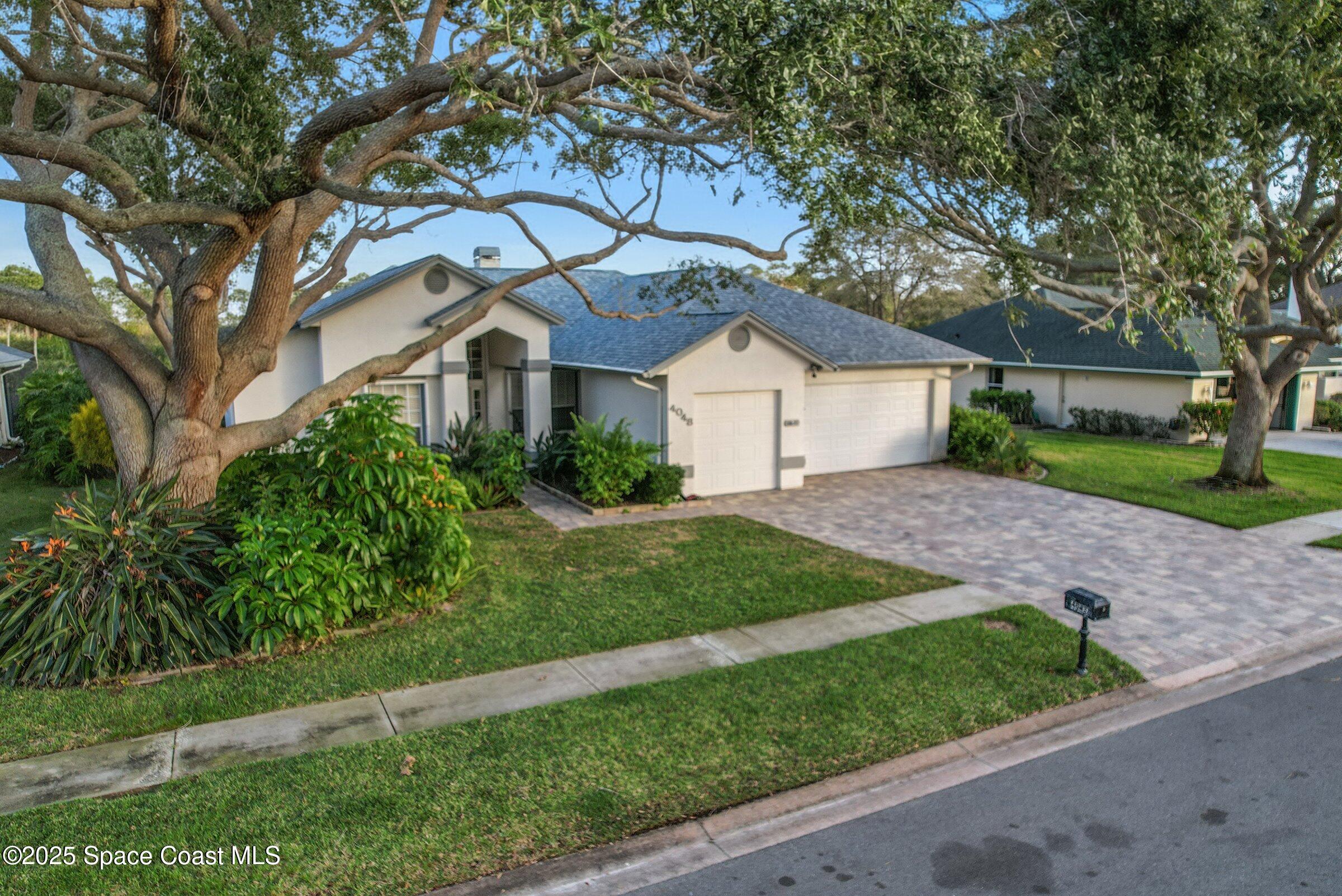 4048 Sand Ridge Drive Merritt Island, FL 32953 - Photo 49 of 70 a front view of a house with a yard and potted plants