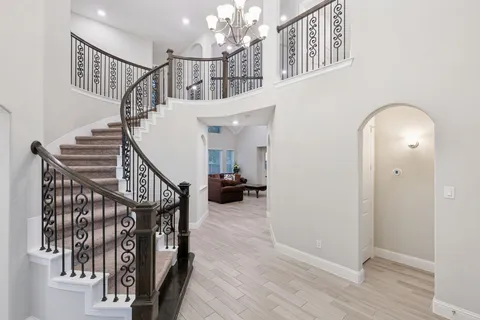 a view of entryway and hall with wooden floor