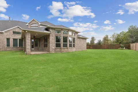 a view of a house with a big yard and a large tree