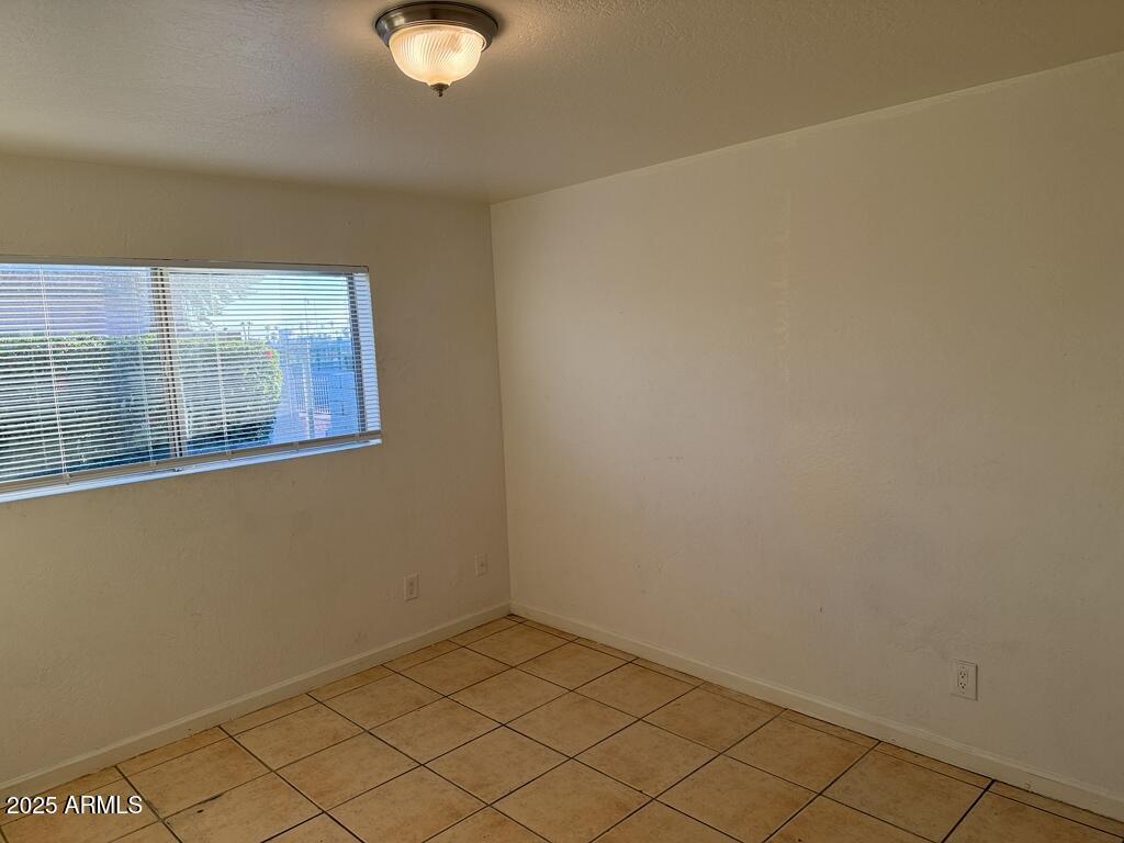 4829 North 37th Avenue, Unit 1 Phoenix, AZ 85019 - Photo 8 of 9 an empty room with windows