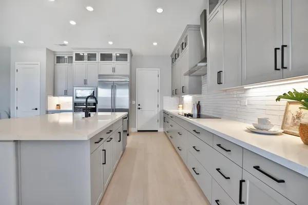a large kitchen with stainless steel appliances kitchen island granite countertop a sink and cabinets
