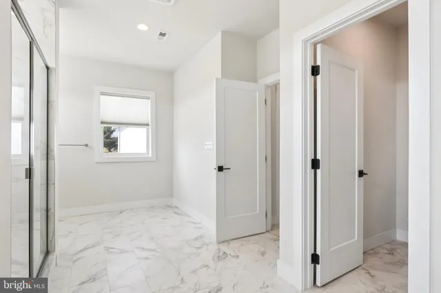 an empty room with windows and entrance to other room