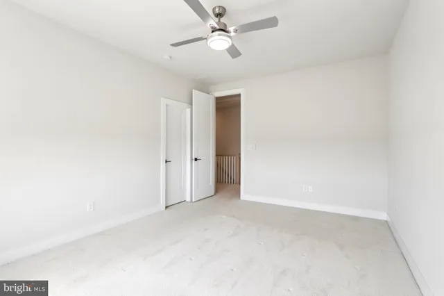 a view of an empty room with a window and a kitchen