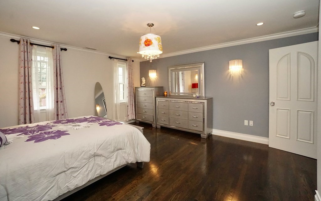 725 Chestnut Street Newton, MA 02468 - Photo 15 of 42 a spacious bedroom with a bed and a chandelier