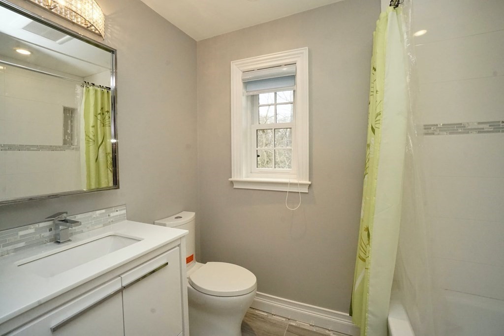725 Chestnut Street Newton, MA 02468 - Photo 27 of 42 a bathroom with a granite countertop sink toilet and mirror