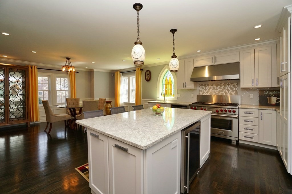 725 Chestnut Street Newton, MA 02468 - Photo 6 of 42 a kitchen with a stove center island a dining table wooden floor and a refrigerator