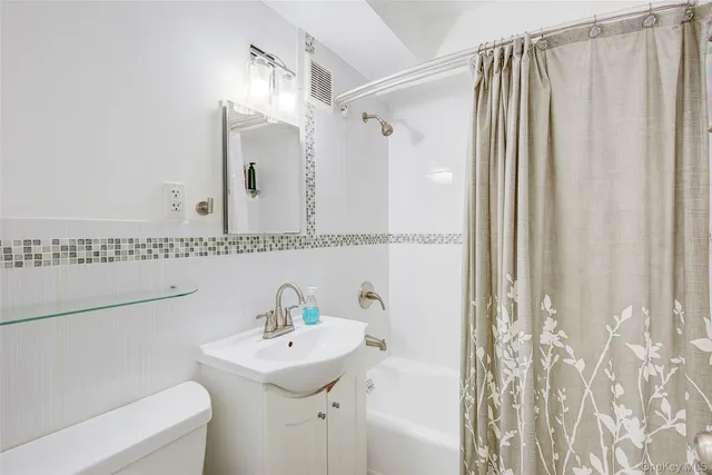 a bathroom with a sink a mirror and a shower curtain