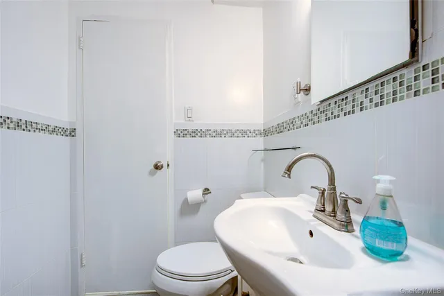 a bathroom with a sink a toilet and mirror