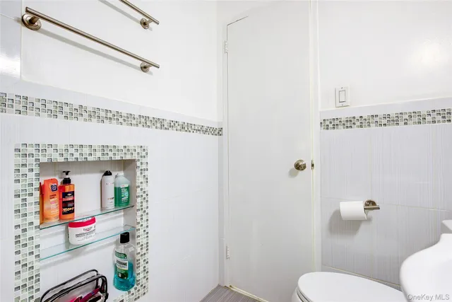 a bathroom with a toilet sink and mirror
