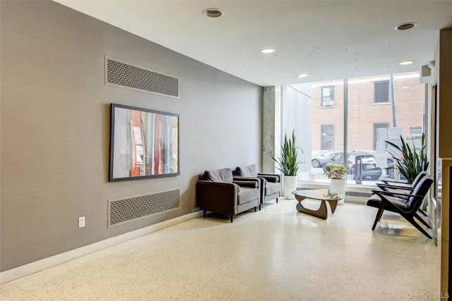 a living room with furniture and floor to ceiling window