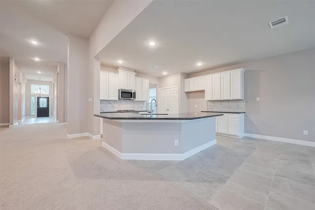 a view of an empty room and kitchen view